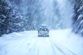 Car Driving on Snow Covered Road During Snowstorm Royalty Free Stock Photo