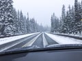 Car driving on snow-covered snowy mountain road in winter snow. Driver`s point of view viewpoint looking through windshield. Royalty Free Stock Photo