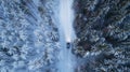 Car driving on snowy road through night forest. View from the air. Royalty Free Stock Photo