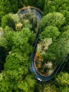 Car driving on a twisty mountain road, seen from above. Aerial view