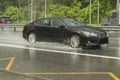 The car is driving on a wet road. Slippery road after rain. Splashes from under the wheels of transport. Rain on the highway Royalty Free Stock Photo