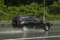 The car is driving on a wet road. Slippery road after rain. Splashes from under the wheels of transport. Rain on the highway Royalty Free Stock Photo