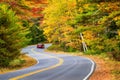 Car driving through winding road with autumn foliage Royalty Free Stock Photo