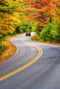 Car Driving Through Winding Road In New England Autumn