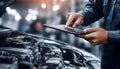 The car engine being diagnosed with a digital tablet by a mechanic Royalty Free Stock Photo