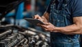 The car engine being diagnosed with a digital tablet by a mechanic Royalty Free Stock Photo