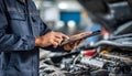 The car engine being diagnosed with a digital tablet by a mechanic Royalty Free Stock Photo