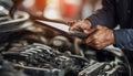 The car engine being diagnosed with a digital tablet by a mechanic Royalty Free Stock Photo