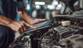 The car engine being diagnosed with a digital tablet by a mechanic Royalty Free Stock Photo