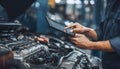 The car engine being diagnosed with a digital tablet by a mechanic Royalty Free Stock Photo