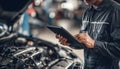 The car engine being diagnosed with a digital tablet by a mechanic Royalty Free Stock Photo