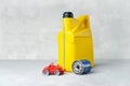 Car engine oil change concept with yellow oil canister, oil filter and little car Royalty Free Stock Photo