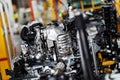 An automobile internal combustion engine stands on the conveyor line of the production hall of an automobile plant.