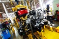 An automobile internal combustion engine stands on the conveyor line of the production hall of an automobile plant.