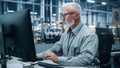 Car Factory Office: Portrait of Male Engineer Working on Computer. Automated Robot Arm Assembly Line