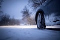 Car and falling snow in winter on forest road Royalty Free Stock Photo