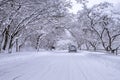 Car and falling snow in winter on forest road with much snow Royalty Free Stock Photo