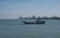 A car ferry crosses the Mekong River between Koh Dach / Silk Island and Phnom Penh, which appears in the background