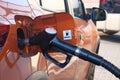 Car fill with diesel at gas station. Pumping diesel fuel in orange car at gas station close up Royalty Free Stock Photo