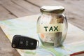 Car finance concept - money glass with word Tax, car key Royalty Free Stock Photo