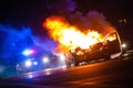 Car on fire at night with police lights in background Royalty Free Stock Photo