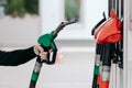 Car fueling concept. Mans hand using fuel nozzle at petrol station. Refueling pistols close up. Diesel and gas. Modern service