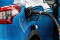 Car fueling at gas station, petrol pump filling fuel nozzle in fuel tank of car at gas station