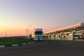 Car fueling station at dawn or in evening during sunset, truck in parking lot. Royalty Free Stock Photo