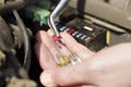 Car fuses on the mechanic`s hand. The mechanic selects the correct fuse.