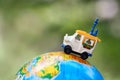 A car on globe on green background. Miniature car toy on globe. Travel concept Royalty Free Stock Photo