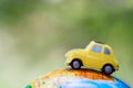 A car on globe on green background. Miniature car toy on globe. Travel concept Royalty Free Stock Photo