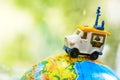 A car on globe on green background. Miniature car toy on globe. Travel concept Royalty Free Stock Photo