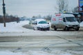 The car goes on a cleared road after heavy snowfall and snowstorms in the city. Traffic lights hang on the wire above