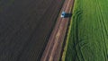 The car goes on a country road. Green wheat field. quadrotor filming.