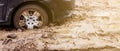 The car got stuck on a dirt road in the mud. Wheel of a car stuck in the mud on the road. Royalty Free Stock Photo