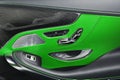 Car green leather and carbon interior details of door handle with windows power seat controls and adjustments. Luxury car inside.