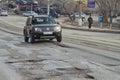 Car has to go around the pit on the road on the tram tracks