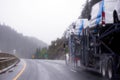 Car hauler semi truck carry cars on the trailer on rainy highway