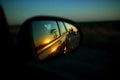 Car on highway. sunset in car mirror reflection. road trip at night.