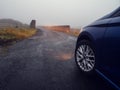 Car illuminating small narrow bridge in a country side, low visibility due to fog. Dangerous road situation because of state of Royalty Free Stock Photo