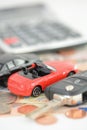 Car insurance concept with toy cars, car key, coins and bills Royalty Free Stock Photo