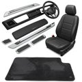 Car interior components including a black leather seat with visible stitching, a steering Royalty Free Stock Photo