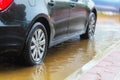 A car in Israel drives through a large puddle of rainwater. The photo illustrates cloudy weather: flood, rain