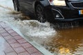 A car in Israel drives through a large puddle of rainwater. The photo illustrates cloudy weather: rain, flood