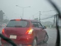 A car with its signal light on carefully making a U-turn in a heavy rain