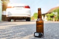 Car key and alcohol bottle on floor with car blurred background meaning for drunk and drive concept