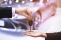 Car key, businessman handing over gives the car key to the other woman on car background. Royalty Free Stock Photo