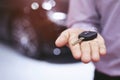 Car key, businessman handing over gives the car key to the other man on car background. Royalty Free Stock Photo