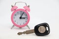 Car key with coin with alarm clock in background. Royalty Free Stock Photo
