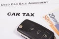 Car key, euro baknotes, inscription car tax and used car sale agreement. Sales, purchases, taxation of automobile. Transportation Royalty Free Stock Photo